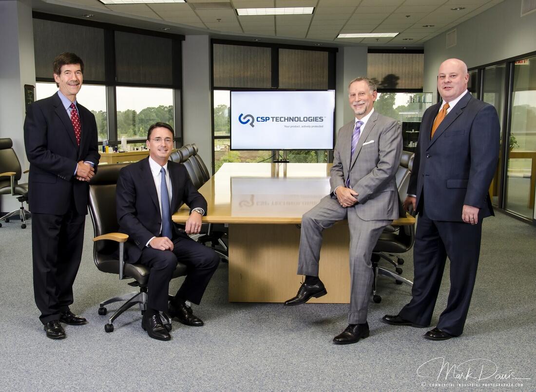 Group of corporate executives photographed around a conference room table